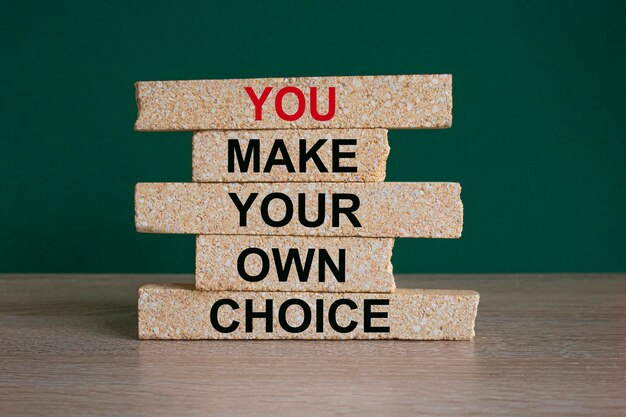 Concept red words You make your own choice on brick blocks Beautiful green background wooden table