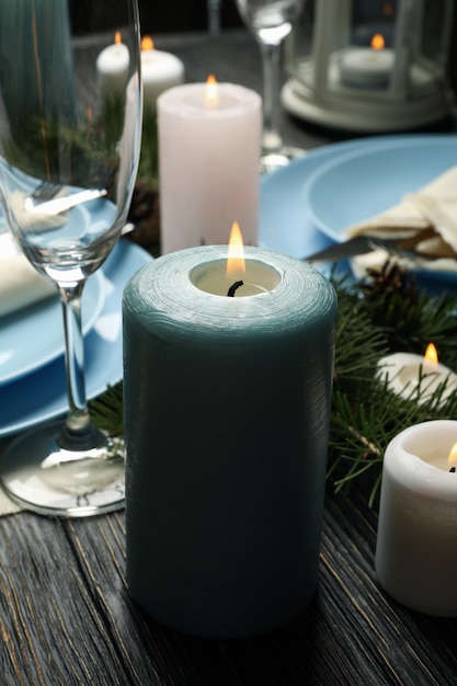 Concept of romantic New year table setting with candles on wooden table