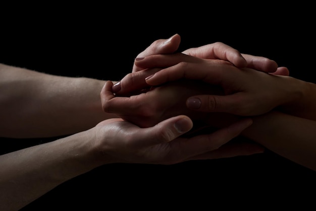 Concept of salvation Hands of two people rescue help Helping hand support Isolated arm on black charity Devoted and empathy Couple relationship