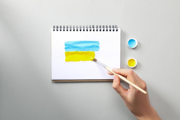 Concept of Save Ukraine woman drawing Ukrainian flag