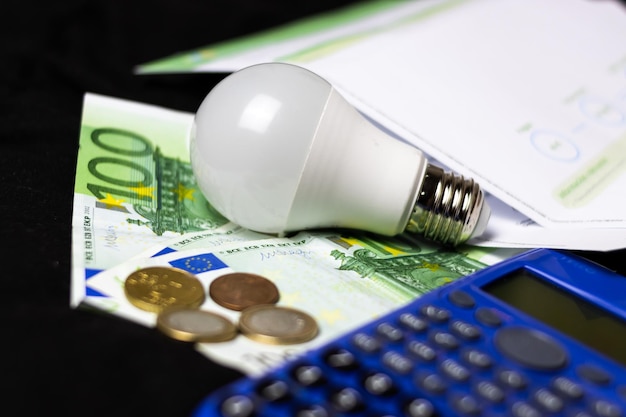 Concept of saving light and money electric light bulb on money and coins Finance and saving electricity