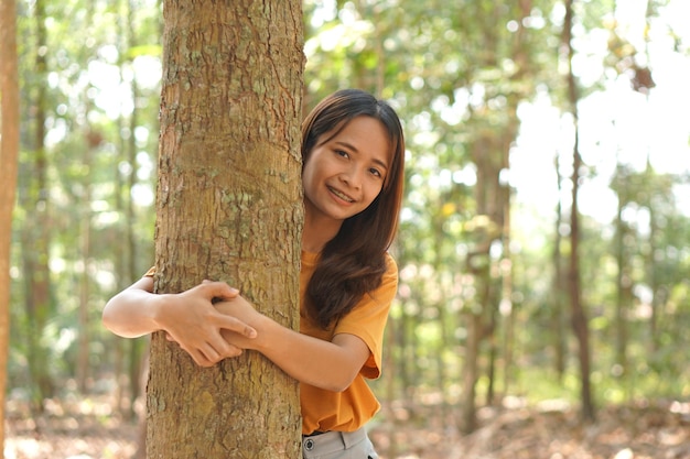 Concept of saving the world Asian woman hugging a tree