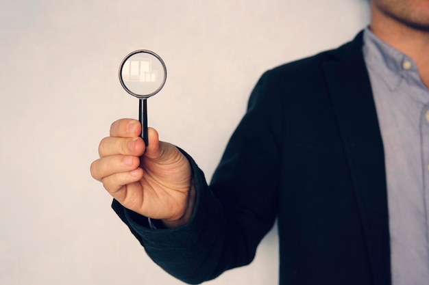 Photo concept of search business man holding magnifying glass