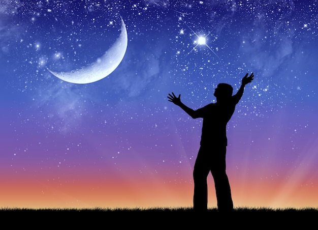 Concept of success. Silhouette of a happy man on the background of the starry sky and the moon