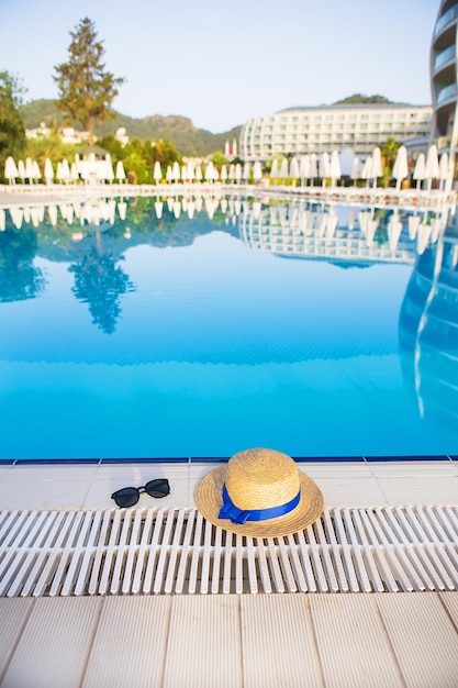 The concept of summer vacation glasses straw hat on the background of the hotel complex