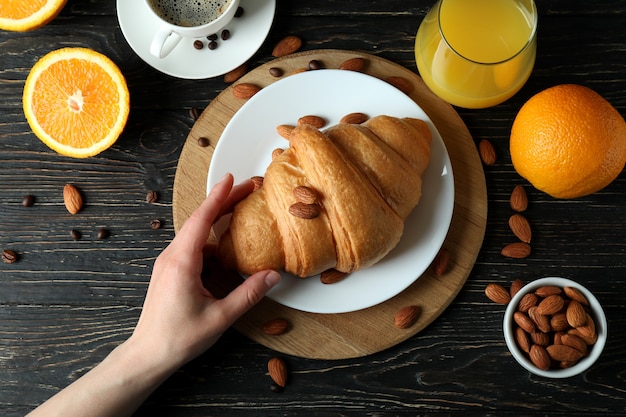 Concept of tasty breakfast with croissant on wooden