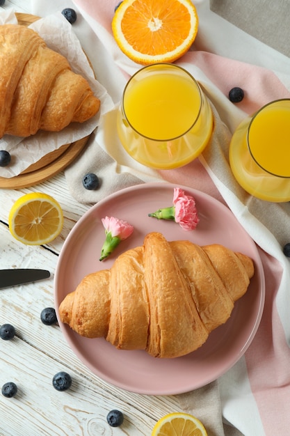 Concept of tasty breakfast with croissants on white wooden