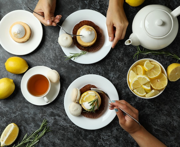 Photo concept of tasty breakfast with lemon cupcakes and macaroons