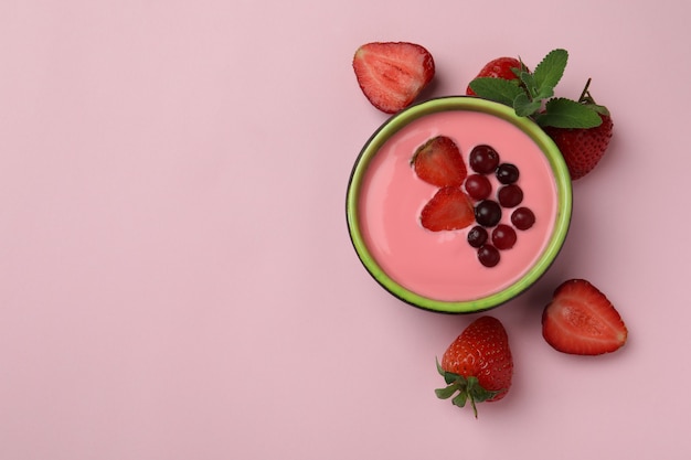 Concept of tasty breakfast with yogurt on pink background