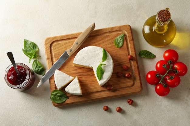 Concept of tasty eating with camembert on white textured background