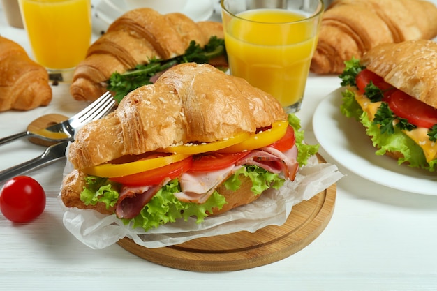 Concept of tasty eating with croissant sandwich, close up