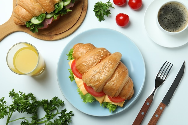 Concept of tasty eating with croissant sandwich, top view