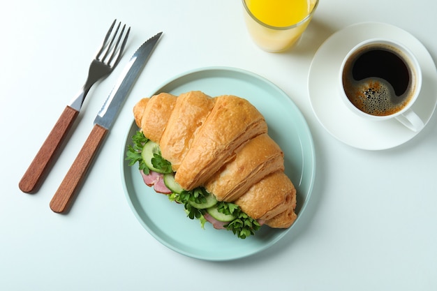 Concept of tasty eating with croissant sandwich on white