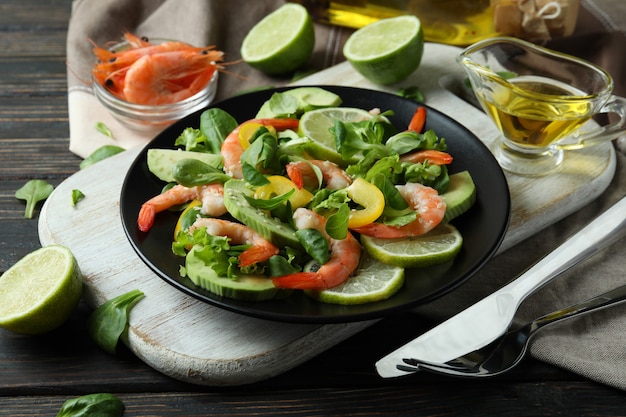 Concept of tasty eating with shrimp salad on wooden table