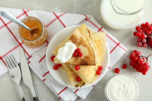 Concept of tasty food with crepes on light textured background