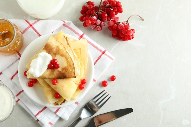 Concept of tasty food with crepes on light textured background