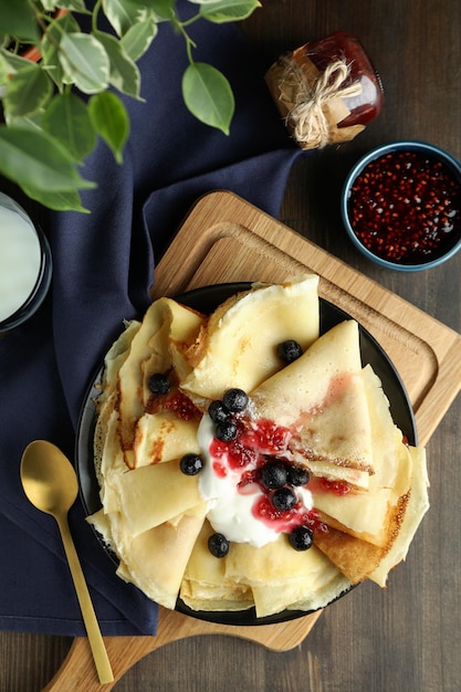 Concept of tasty food with crepes on wooden background