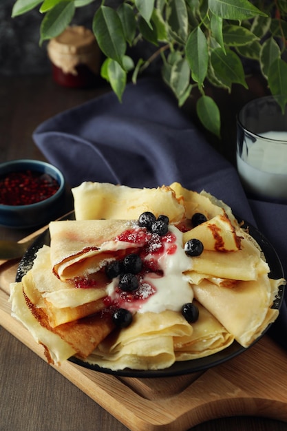 Concept of tasty food with crepes on wooden table