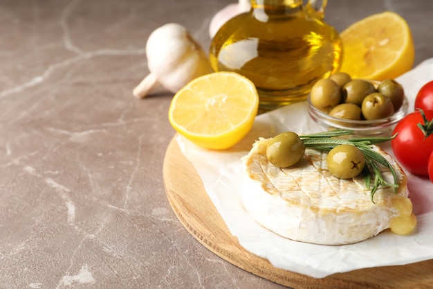 Concept of tasty food with grilled camembert on gray texture table.