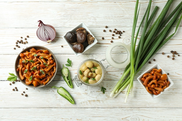 Concept of tasty food with marinated mushrooms on wooden table