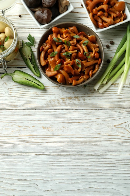 Concept of tasty food with marinated mushrooms on wooden table