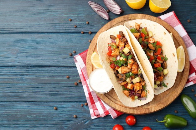 Concept of tasty food with taco on wooden background