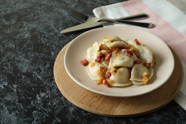 Concept of tasty food with vareniki or pierogi on dark table