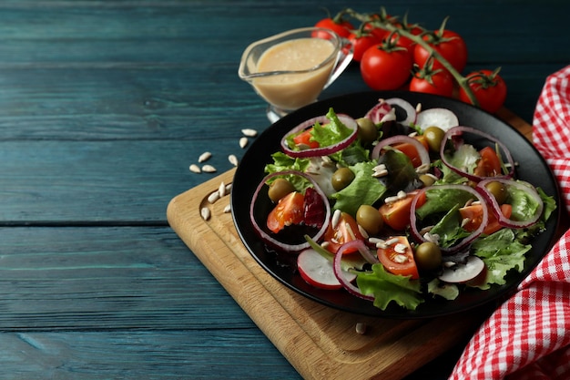 Concept of tasty food with vegetable salad with tahini sauce on wooden background