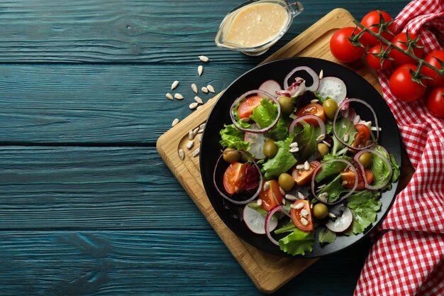 Concept of tasty food with vegetable salad with tahini sauce on wooden background