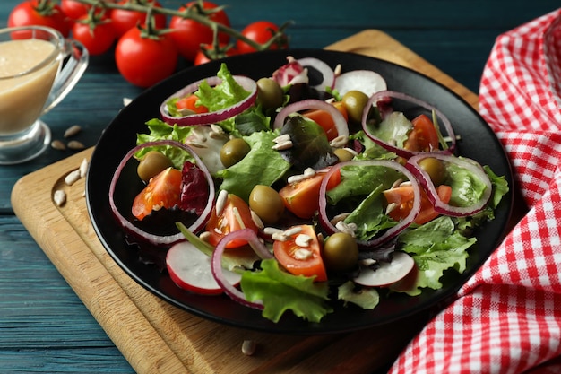 Concept of tasty food with vegetable salad with tahini sauce on wooden background