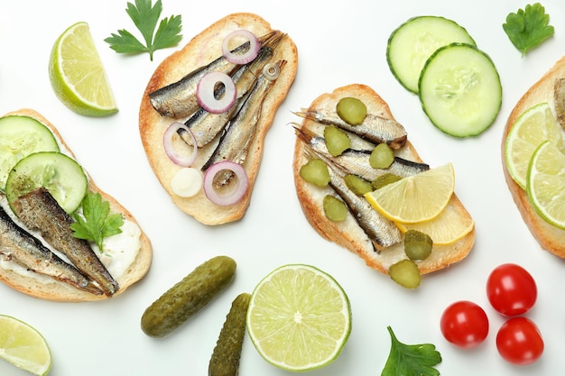 Concept of tasty snack with sandwiches with sprats on white background