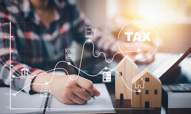 Concept tax payment optimisation business financewoman using pen write note book with taxes icon on technology screenincome tax and property business individuals and corporations such as VAT