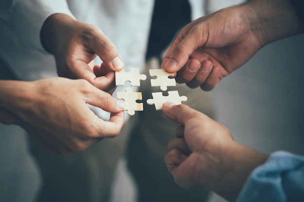 Concept of teamwork and partnership Hands join puzzle pieces in the office