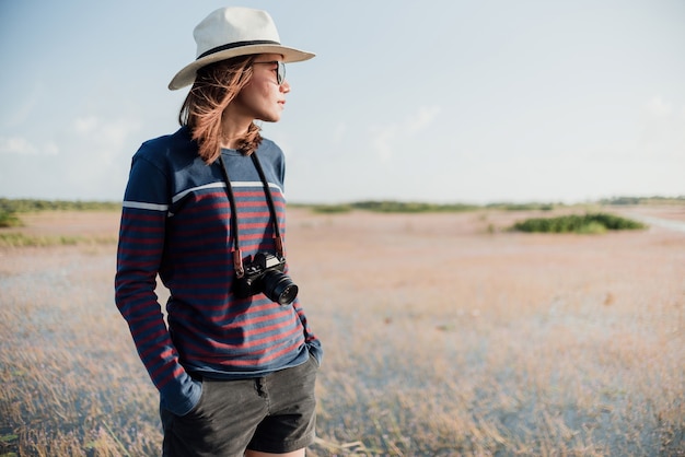 The concept of a tourist photographing an Asian woman, holding a camera on her neck Hand pickpocket Look to the side