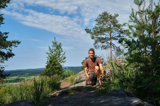 Concept of travel in Russia Mount Paaso in Sortavala Karelia Young man with German shepherd dog