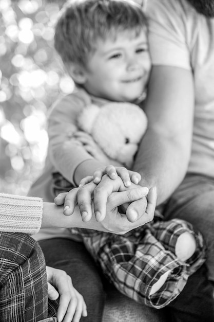 Concept of unity support protection happiness Child hand closeup into parents Black and white