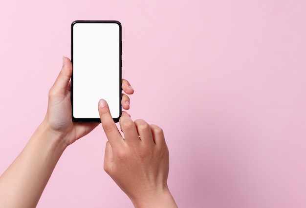 Concept of use of the smartphone. A smartphone with a white blank screen in the hands of a woman.