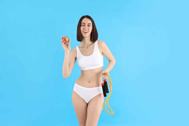 Concept of weight loss with slim young woman on blue background