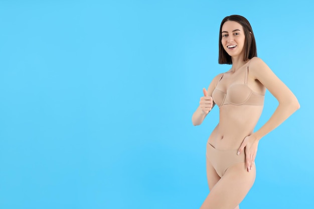 Concept of weight loss with slim young woman on blue background