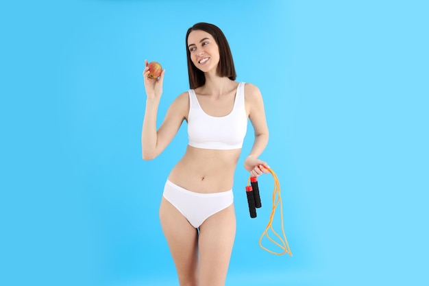 Concept of weight loss with young slim woman on blue background