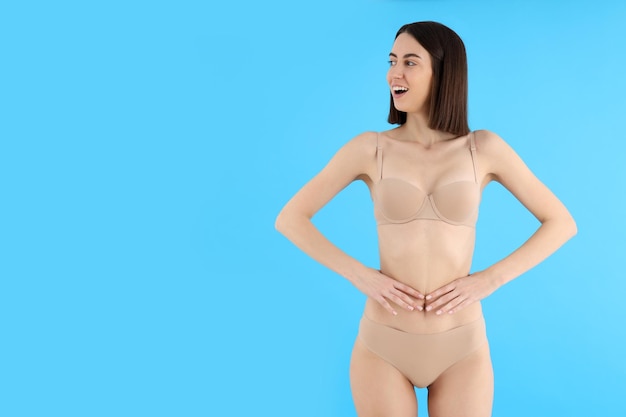 Concept of weight loss with young slim woman on blue background