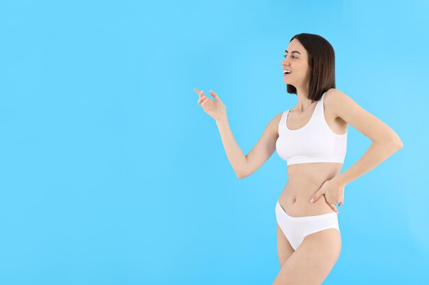 Concept of weight loss young woman on blue background