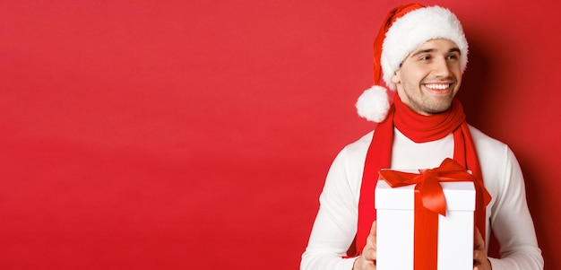 Concept of winter holidays christmas and lifestyle closeup of attractive man in santa hat and scarf ...