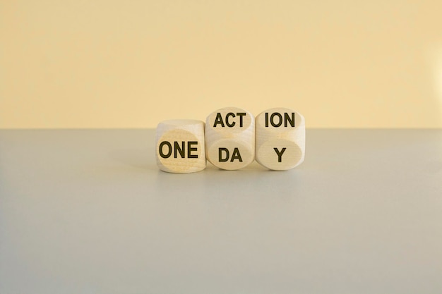 Concept words One day and One action on wooden cubes Beautiful gray table beige background