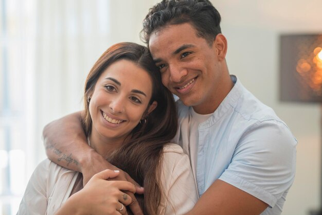 Concept of young interracial couple in love and relationship Boy hug and protect girlfriend at home Life and future together man and woman New apartment happiness satisfaction portrait Smile