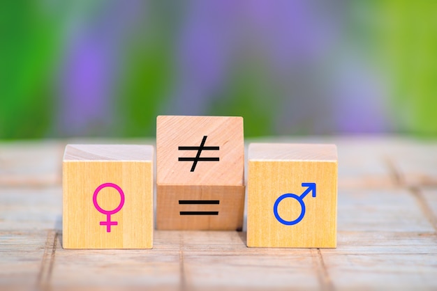 Concepts of gender equality.  Wooden cube with symbol unequal change to equal sign