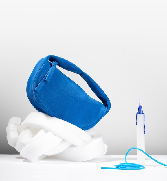 Conceptual creative modern Still life Abstract balance composition Cobalt blue clutch made from an artificial suede on a minimalistic pure white background