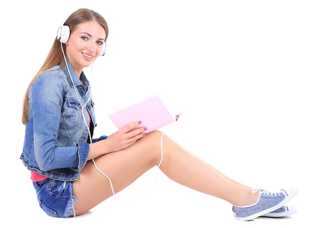 Conceptual image of audio bookBeautiful girl with book and headphones isolated on white