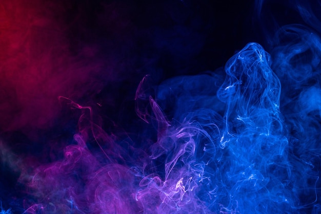 Conceptual image of colorful red and blue color smoke on dark black background