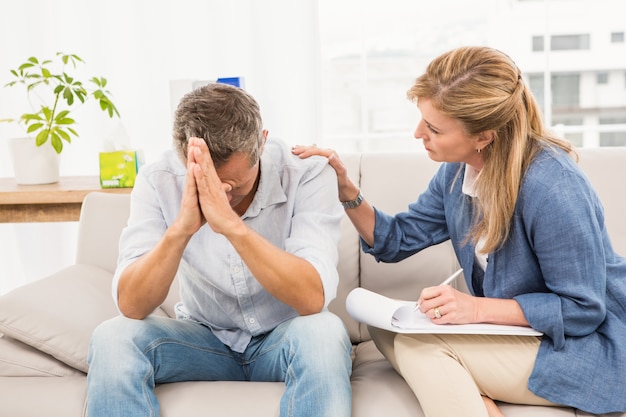 Concerned therapist comforting male patient